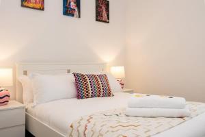 a bedroom with a white bed with two pillows at The Didsbury Loft in Manchester
