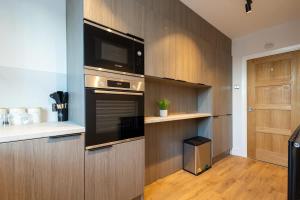 eine Küche mit eingebautem Backofen und Mikrowelle in der Unterkunft The Withington in Manchester