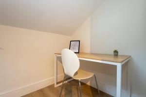 ein weißer Stuhl neben einem Schreibtisch in einem Zimmer in der Unterkunft The Withington in Manchester