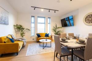 ein Wohnzimmer mit einem gelben Sofa und einem Tisch in der Unterkunft The Withington in Manchester