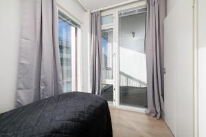 ULEABO New and bright downtown 3-room apartment في أولو: غرفة نوم مع نافذة كبيرة مطلة