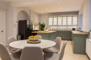 a kitchen with a table and chairs in a kitchen at The Coach House - Grade 2 Listed in Hale +61 photos