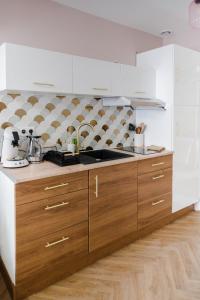 una cucina con lavello e mobili in legno di La Parenthèse Fleurie - Suite avec balnéo au coeur de Bergerac a Bergerac Altre 34 foto