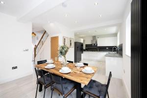 a kitchen and dining room with a wooden table and chairs at The Wilmslow House Free Parking - Close to Airport in Alderley Edge +30 photos