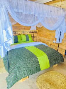 a bedroom with a bed with a canopy and a rug at Twende Home lodge in Arusha +1 photo