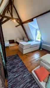 a attic room with two beds and a rug at House - comfortable - spacious - 15' from Lille in Leers