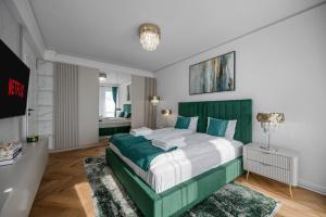 a bedroom with a green and white bed and a television at FLH - Panoramic Garden Luxury Apt in Cristian