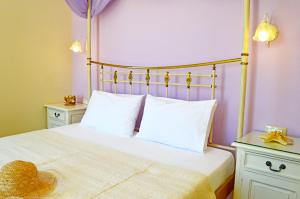 ein Schlafzimmer mit einem Bett mit weißen Laken und einem Hut darauf in der Unterkunft Kalia Studios in Agia Anna
