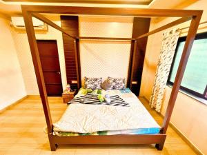 a bedroom with a canopy bed in a room at StayMist - Casa Atlas Villa in Lonavala