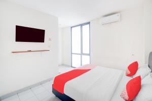 ジャカルタにあるHotel O J&B Smart Jatinegaraのベッドルーム(赤い枕のベッド1台、テレビ付) +19枚の写真