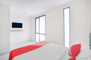 ジャカルタにあるHotel O J&B Smart Jatinegaraのベッドとテレビのある白い部屋