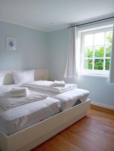 two beds in a bedroom with a window at Nebel-s-Hues-Eg in Nebel
