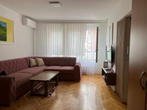 a living room with a couch and a table at Apartment Oriku - Prishtinë in Prishtinë