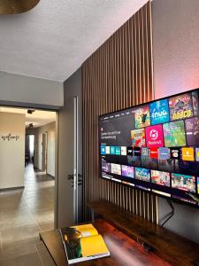 a living room with a large flat screen tv on a wall at STAYtion Ferienhaus Balingen in Balingen