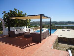 a patio with a couch and a gazebo next to a pool at Casa da Paz in Odeleite