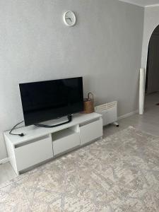 a living room with a flat screen tv on a white entertainment center at Asman Loft in Uralsk