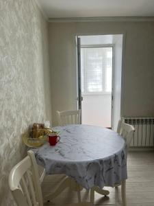 a dining room with a white table and chairs at Asman Loft in Uralsk