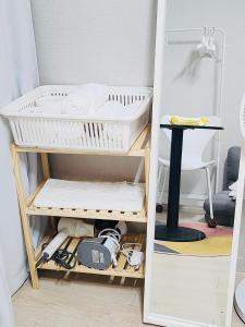 ein Raum mit einem Regal mit einem Korb und einem Tisch in der Unterkunft DDP Families & Friends House in Seoul