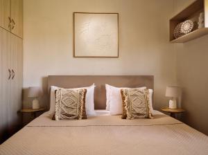 ein Schlafzimmer mit einem großen Bett und Kissen in der Unterkunft Aristotle Luxury Apartment with Sea View in Argassi