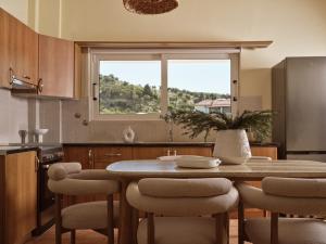 eine Küche mit Tisch und Stühlen und einem Fenster in der Unterkunft Aristotle Luxury Apartment with Sea View in Argassi