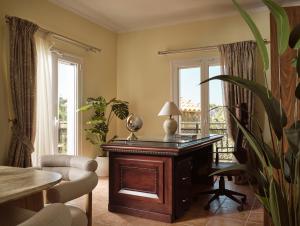 ein Wohnzimmer mit einem Schreibtisch und einem Balkon in der Unterkunft Aristotle Luxury Apartment with Sea View in Argassi