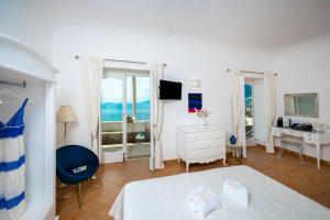 a bedroom with a bed and a desk with a window at Villa Santa Chiara Positano Suites in Positano