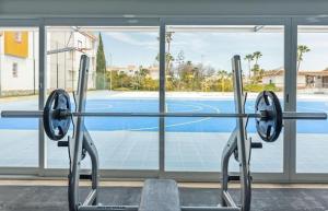 a gym with a view of a tennis court at Resort house with Pools and Private beach in Tavira