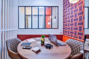 a room with a table with a laptop and chairs at WS Mouffetard - Panthéon in Paris