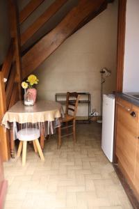 a kitchen with a table with a vase of flowers on it at Tour des hirondelles in Écuras