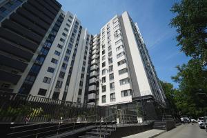 a tall white building with a fence in front of it at Modern Stay Rîșcani, AC, WiFi, Washer in Chişinău