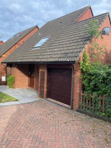 a brick house with a garage at 3BR House Self Check In Parking By PlushPad in Shenley Lodge
