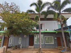 a house with palm trees in front of it at Dungkaew lakeview resort in Amphoe Ban Dung