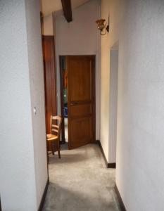 an empty hallway with a wooden door and a chair at Tour des hirondelles in Écuras