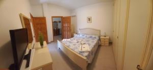 a room with a bed and a tv in it at Molentargius Domus in Quartu SantʼElena