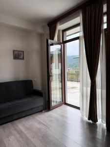 a living room with a couch and a sliding glass door at Bakuriani, Trialeti Residence in Bakuriani