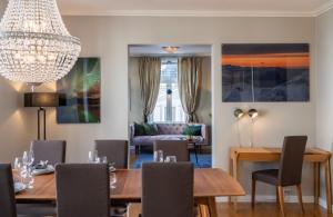 a dining room with a table and chairs and a chandelier at Enter Tromsø - Exclusive Apartments in Tromsø