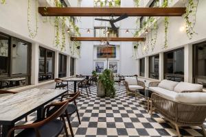 a restaurant with tables and chairs and a checkered floor at Hotel 1935- By Adam Hotels in Tel Aviv