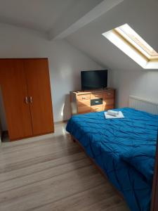 a bedroom with a bed and a dresser and a television at Apartament Adriano in Turda