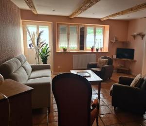 un soggiorno con un divano e un tavolo di Le Refuge Comtois a La Longeville