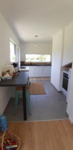 a kitchen with a counter and a table in a room at Au calme en pays d'Oust et de Brocéliande in Montertelot