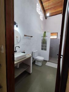 ein Badezimmer mit einer weißen Toilette und einem Waschbecken in der Unterkunft Casa Colibri - Piscina Privativa - Patacho Lages in Pôrto de Pedras