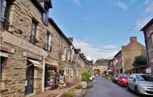 a street in an old town with cars parked at Au calme en pays d'Oust et de Brocéliande in Montertelot