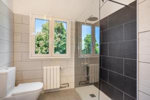 a bathroom with a toilet and a glass shower at Picarus Home in Tacoronte +18 photos