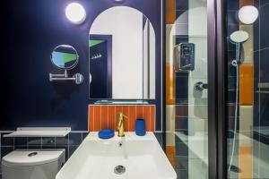 a bathroom with a sink and a mirror at ARK Hôtel Paris Boulogne in Boulogne-Billancourt