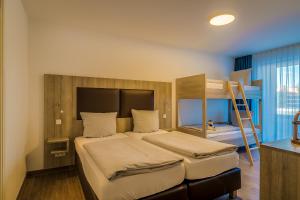 a bedroom with a bed and a bunk bed at LAGOVIDA Möwenblick c am Störmthaler See in Großpösna