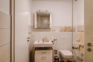 a small bathroom with a sink and a toilet at LAGOVIDA Möwenblick c am Störmthaler See in Großpösna +36 photos