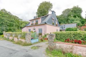 a pink house with a fence and flowers at La Renardière - Chambre in Férel
