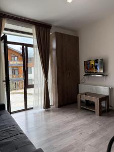 a living room with a couch and a tv and a table at Bakuriani, Trialeti Residence in Bakuriani +3 photos