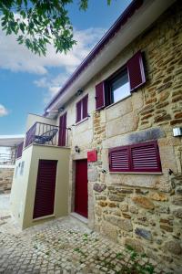 a brick building with red doors and windows at Tréguas D'Inverno I in Seia