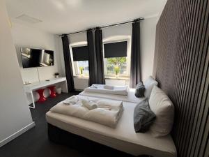 a bedroom with two beds and a large window at BFF Airport Messe Schlaf - Düsseldorf in Düsseldorf